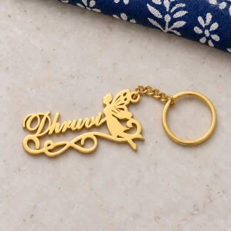 Fairy Angel Personalized Name Keychain in a golden finish, on a light stone display