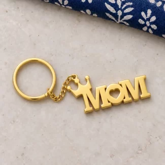Heart & Crown MOM Keychain in a golden finish, on a light stone display