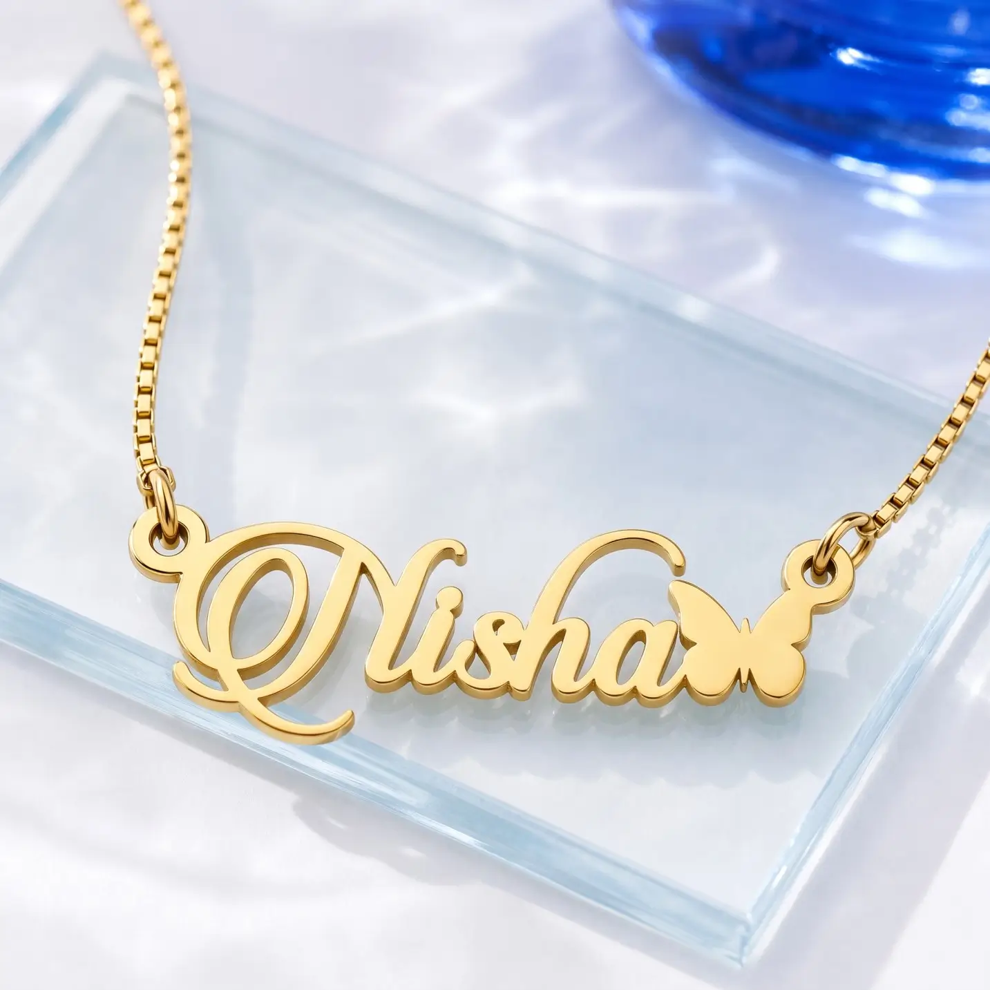 Personalized Butterfly Name Necklace – Glass Display Gold-tone script name necklace with a small butterfly on a clear glass display