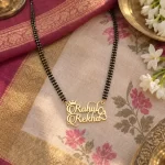Stylish Couple Name Necklace with a black-beaded chain on floral fabric