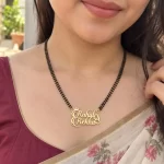 Stylish Couple Name Necklace with a black-beaded chain worn with a sari