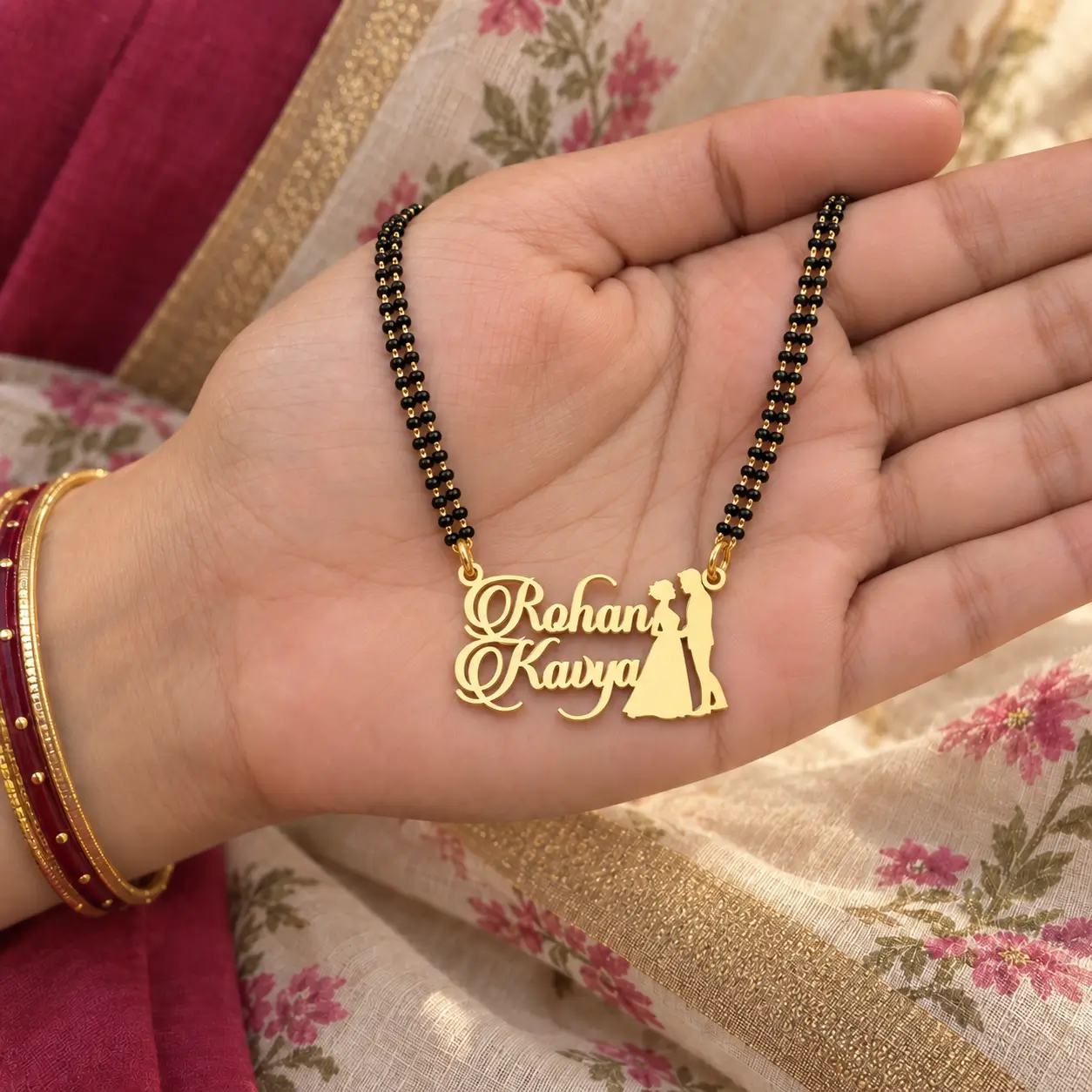 Couple Design Name Necklace – With a black-beaded chain held in a hand Couple Design Name Necklace with a black-beaded chain held in a hand