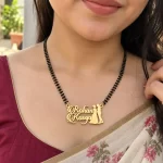 Couple Design Name Necklace with a black-beaded chain worn with a sari