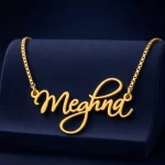 Gold-tone curved cursive name necklace on a navy velvet display