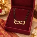 Side Heart Infinity Couple Name Necklace with a black-beaded chain in a red display box