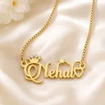 Gold-tone name necklace with a sparkling crown, star and heart on ivory satin