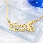Gold-tone fairy silhouette name pendant on a clear glass display