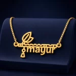 Gold-tone flute and feather name pendant on a navy velvet display