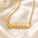 Gold-tone simple name pendant with a small heart on ivory satin