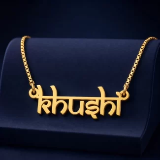 Gold-tone Indian style name necklace on a navy velvet display
