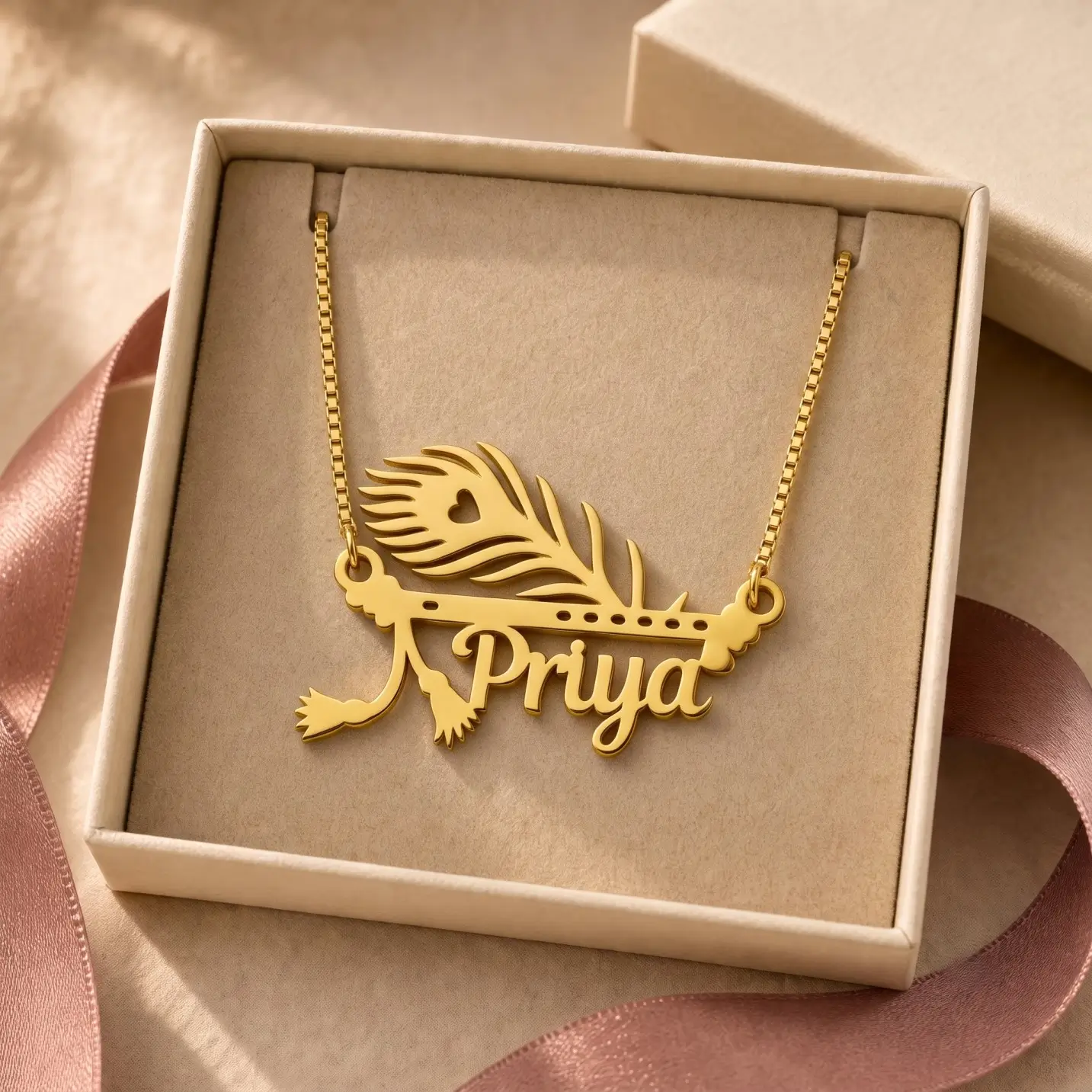 Mor Pankh Personalized Name Pendant – Jewellery Box Gold-tone peacock feather and flute name pendant displayed in an open beige jewellery box