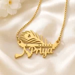 Gold-tone peacock feather and flute name pendant on ivory satin