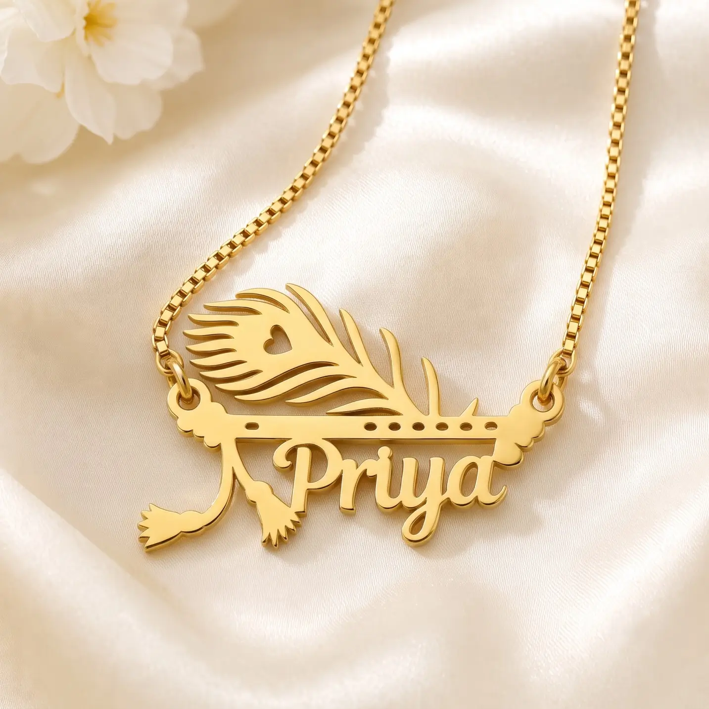 Mor Pankh Personalized Name Pendant – Satin Detail Gold-tone peacock feather and flute name pendant on ivory satin