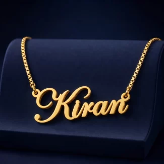 Gold-tone stylish cursive name pendant on a navy velvet display