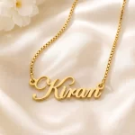 Gold-tone stylish cursive name pendant on ivory satin